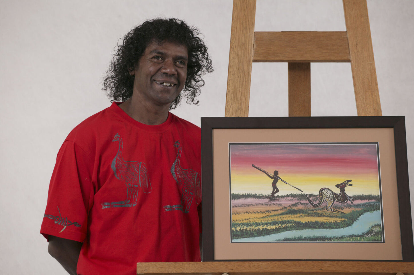 Lewis Langton standing next to his Kangaroo Hunting artwork