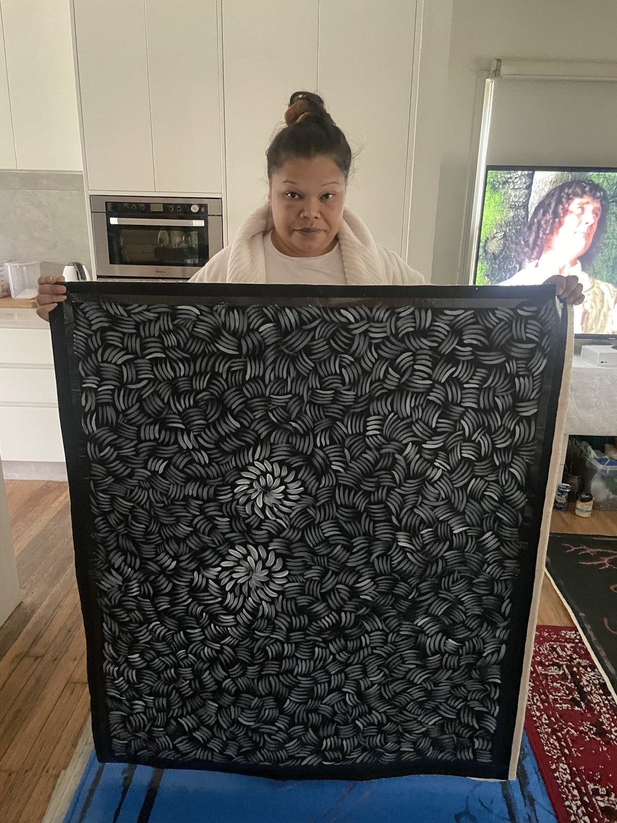 Nyrulla Possum holding a large Bush Medicine artwork