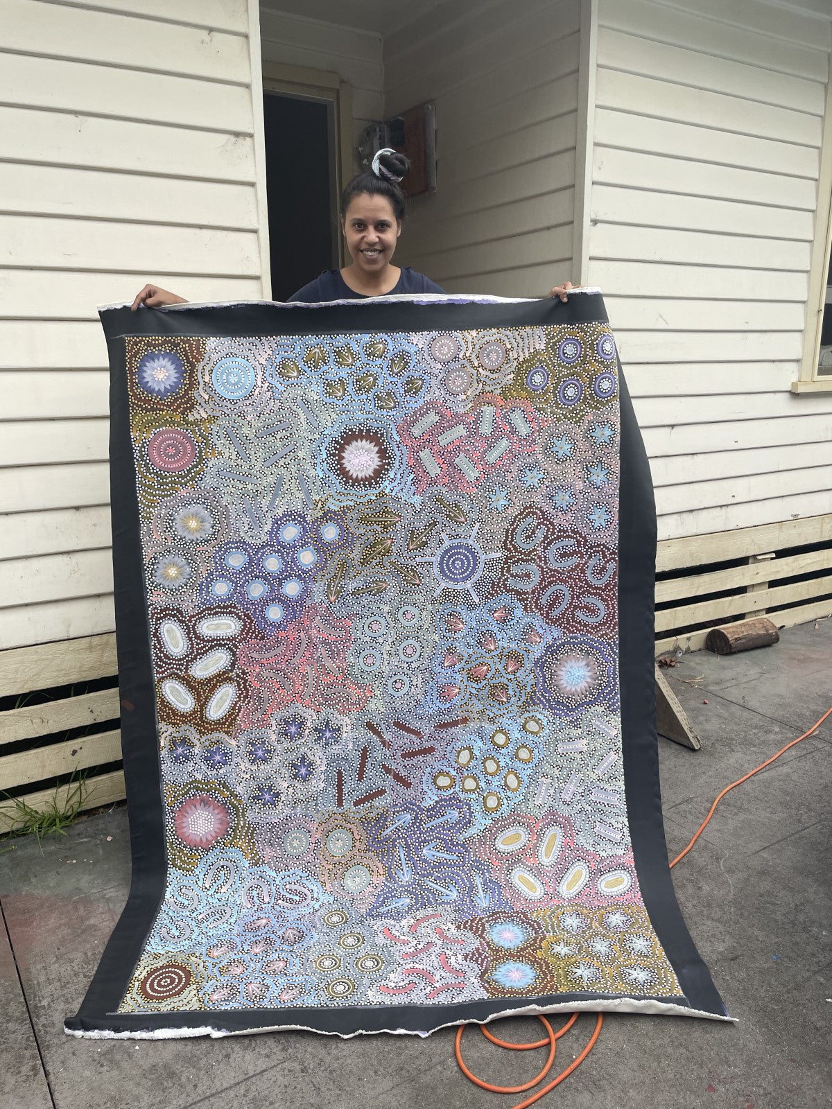 Chelsea Possum holding a large, colorful Grandmothers Country